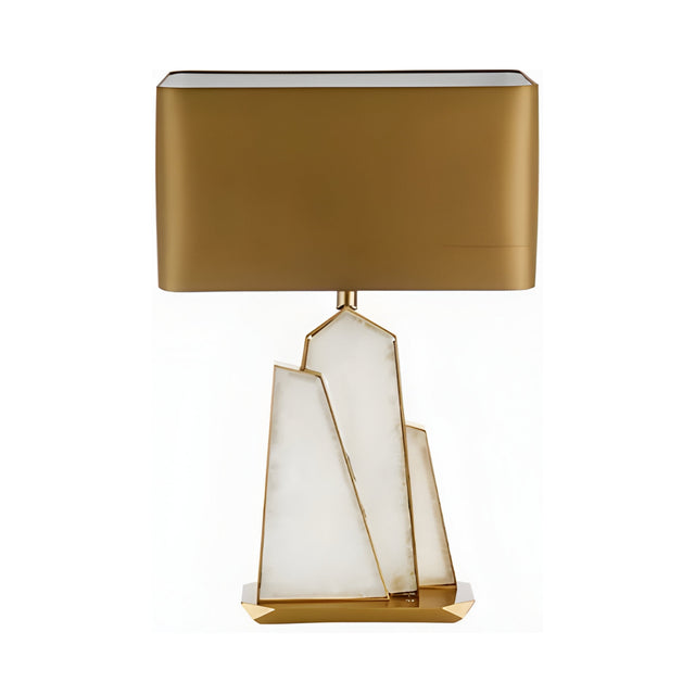 The Virella 1 Light Faceted Stone Table Lamp features a brass rectangular shade and a sculpted soft white and gold angular stone base, shown against a plain white background.