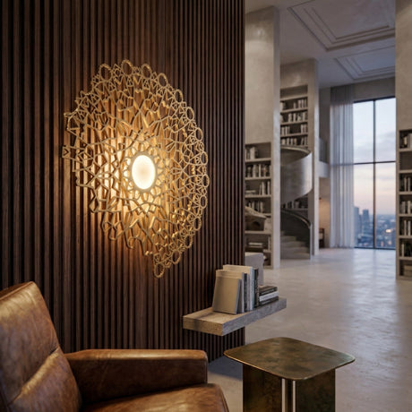 A modern living space featuring a Notredame LED Large Wall Light - Gold with intricate geometric design, a brown leather armchair, metallic side table, and a spiral staircase with built-in bookshelves.