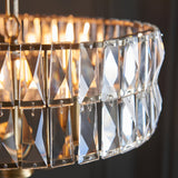Close-up of the Endon Bevmont 3 light pendant showing tiered clear cut faceted glass panels on a brass frame with illuminated E14 lamps.