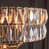 Close-up of the Bevmont 5 Light Pendant in brass, showing faceted crystal-look glass panels linked with brass frames and pins.