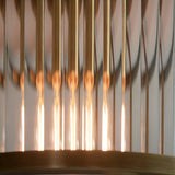 Close-up of the Rothbury flush ceiling light in antique brass, showing ribbed glass rods and warm glowing bulbs beneath the brass mount.