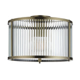 Rothbury Flush Ceiling Light in antique brass, a drum-shaped fixture with vertical glass rods around a central bulb, shown on a plain white background.