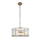 Rothbury 3 Light Pendant in antique brass with a drum frame and clear ribbed glass panels, hung from a chain on a plain white background.