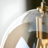 Close-up of the Brockmere Pendant in brass and gold, showing the oval champagne lustre glass shade and satin brass fitting with visible E27 lamp holder.