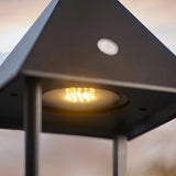 Close-up of the Endon Brenmont large table lamp in matt black, showing the illuminated warm white LED beneath the pitched aluminium roof.