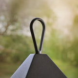 Close-up of the loop handle and matt black aluminium peaked top of the Endon Brenmont large table lantern, shown outdoors against blurred greenery.