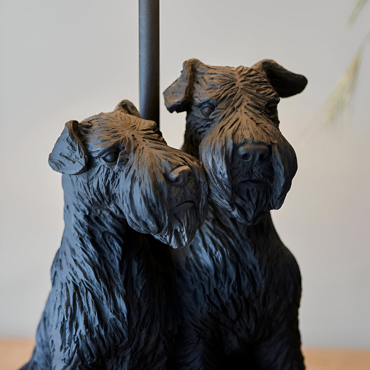 Danegrove Table Lamp base close-up showing two textured resin dog figures in matt black, with lamp pole visible against a plain light background.