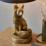 Endon Brambury table lamp with a hand-painted vintage gold resin fox base and black tapered fabric shade, on a wooden side table.