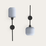 Whiteberry Lantern wall lights with ribbed opal glass cylinder shades on slim black iron stems and round wall mounts, shown in two orientations on a plain white background.
