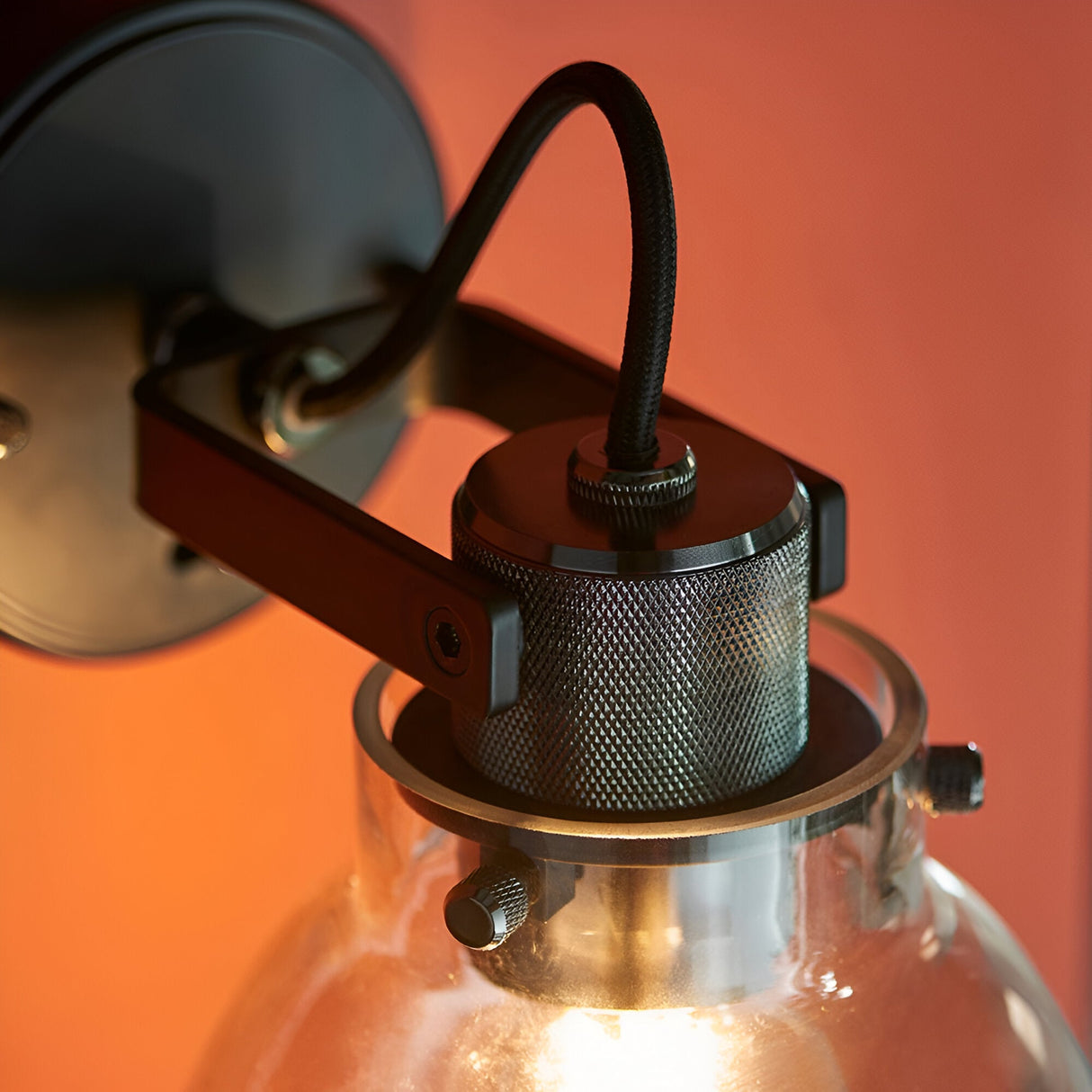 Camden Wall Light in chrome, black & grey, close-up of the knurled fitting, braided cable, and stepped bracket with glass shade below.
