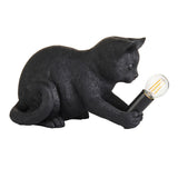 Endon Brockwick matt black resin kitten table lamp holding an E14 filament bulb in its paws, shown on a plain white background.