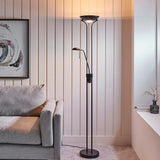 Endon Cliffcombe mother and child floor lamp in matt black with opal glass uplighter and adjustable reading arm, shown beside a grey sofa in a living room.