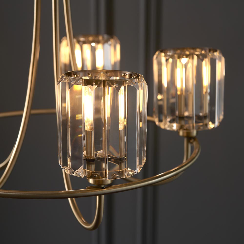 Endon Clementine 5 light pendant close-up showing cut faceted glass shades with lit E14 filament lamps on curved brass plated arms.