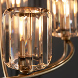 Close-up of Endon Clementine 5 Light Pendant in brass, showing cut faceted clear glass shades on curved plated arms with lit E14 filament lamps.