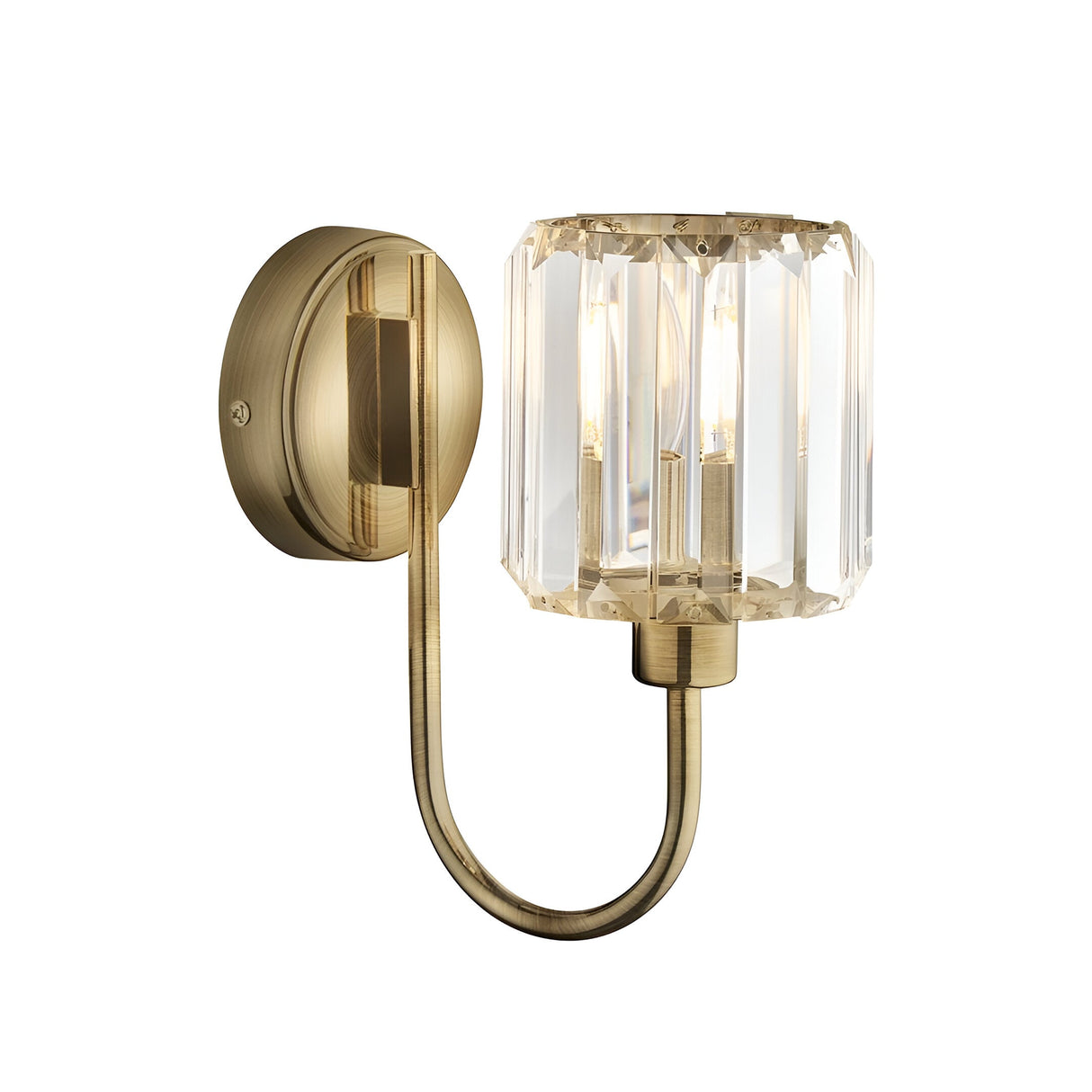 Endon Clementine wall light in brass with a single faceted clear glass cylindrical shade on a curved arm and round backplate, shown on a white background.
