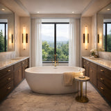 Niori Selvara LED Medium Alabaster Wall Lights in matt black flank tall mirrors above wooden vanities in a marble bathroom with a freestanding tub.