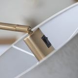 Close-up of the Bevmere Floor Lamp in aged brass, showing the brushed metal joint, rocker switch, and fabric shade edge.