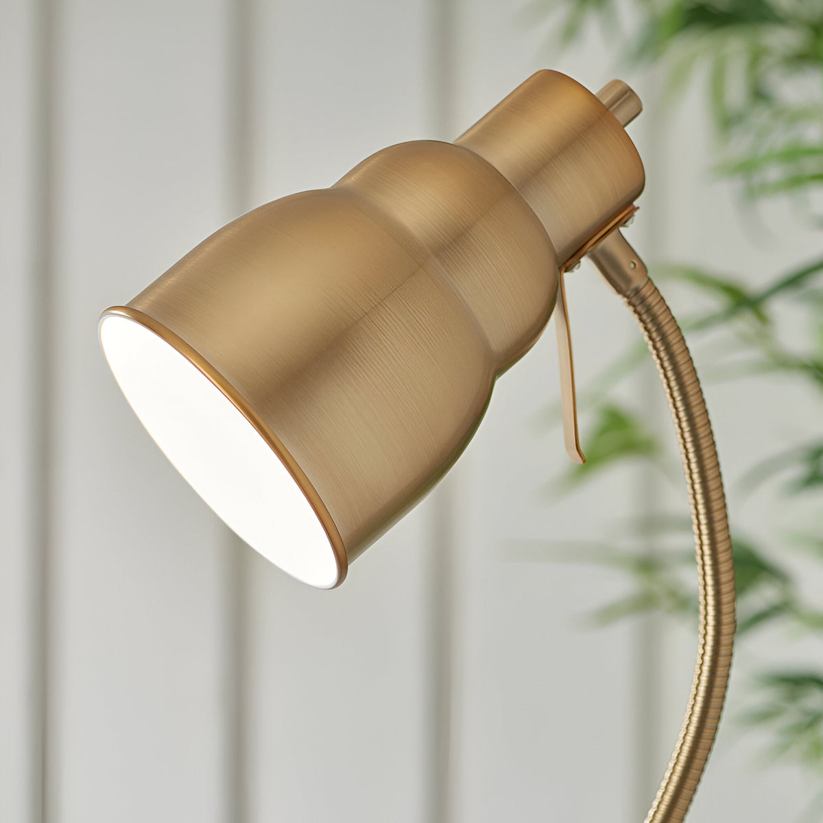 Close-up of the Endon Bevleigh floor lamp head in brushed aged brass, showing the bell-shaped shade and flexible gooseneck arm.