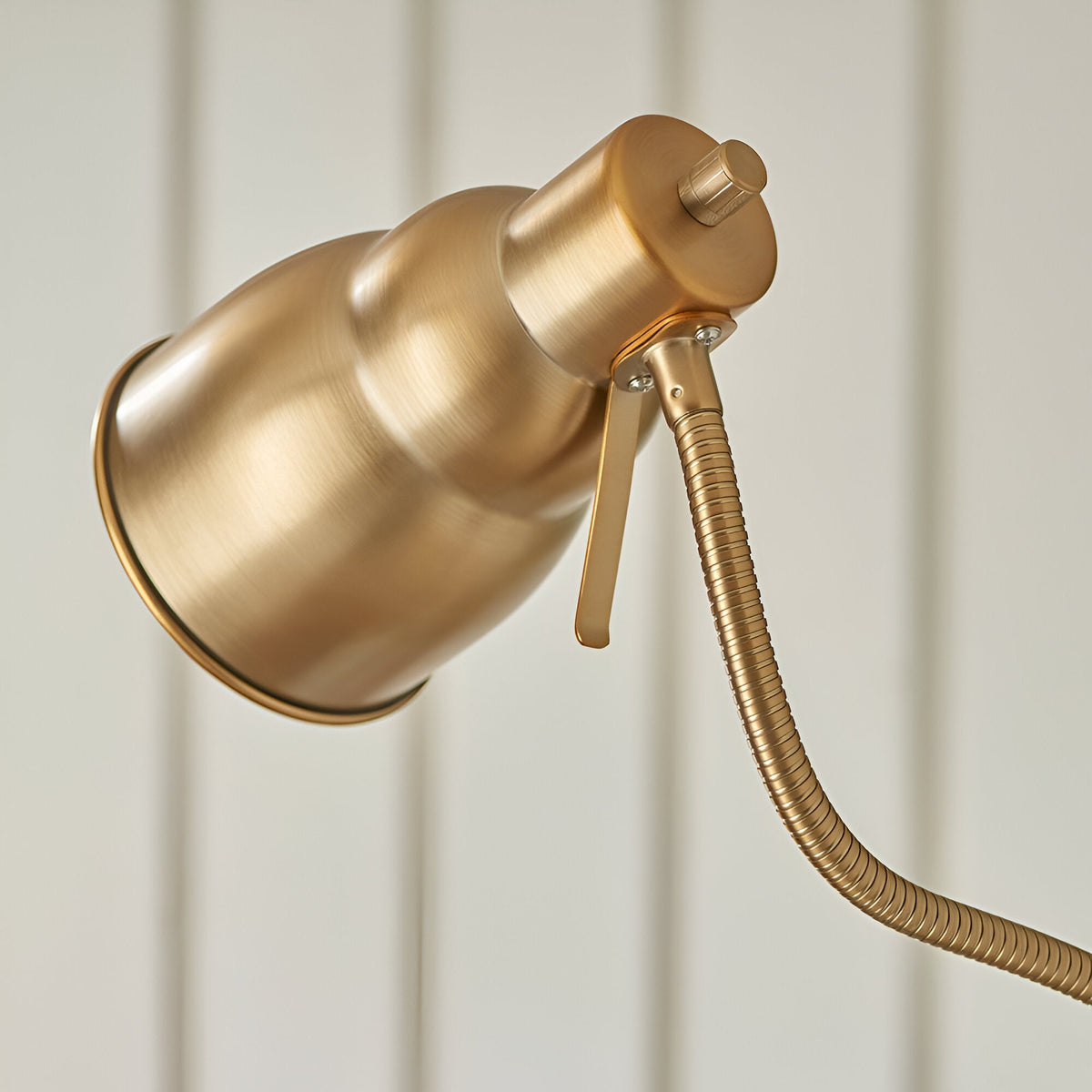 Close-up of Endon Bevleigh floor lamp head in brushed brass, showing the tapered shade, adjustment lever, and flexible gooseneck arm.