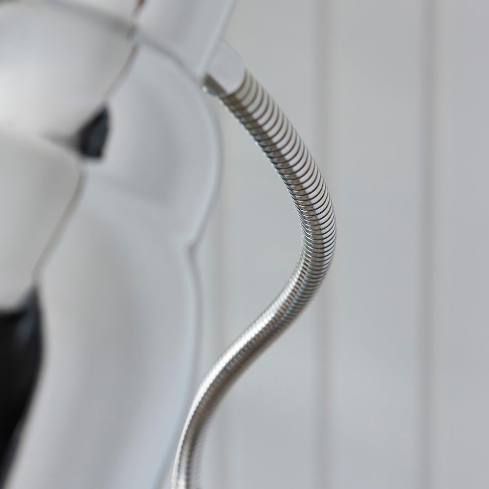 Close-up of the Endon Bevleigh floor lamp's flexible nickel arm curving in a coiled S-shape against a pale panelled background.