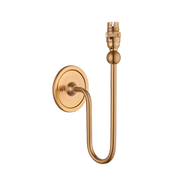 Endon Cliffleigh wall light with slim curved upright arm, round flat back plate and B22 lampholder in brushed aged brass, shown on a white background.