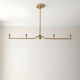 Endon Cliffleigh 4 light linear pendant in brushed aged brass, with a curved bar, sphere detail and B22 lamp holders, shown without shades on a white ceiling.