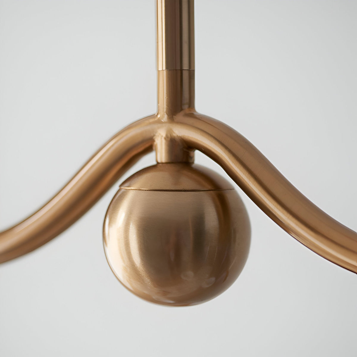 Close-up of the Endon Cliffleigh linear pendant showing the brushed aged brass bar, central stem junction, and decorative sphere detail.