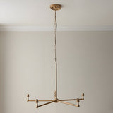 Cliffleigh five light pendant with brushed brass frame and five B22 lamp holders on splayed arms, hung from a long chain in a neutral room.
