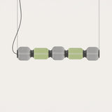 Greenberry LED 5 Light Linear Pendant with alternating grey and green ribbed glass shades and black collars, suspended on twin cables against a plain light background.
