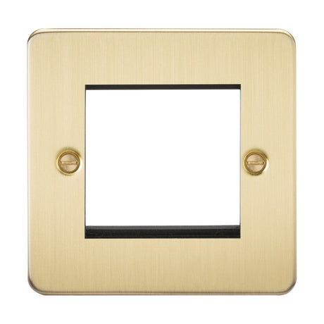 The 2 Gang Modular Faceplate - Brushed Brass (Flat Plate) has a square design with a central cutout for the switch and two visible screws on the left and right for mounting.