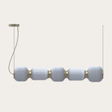 Whiteberries Echo LED 5 Light Ribbed Glass Pendant in gold, five white blown-glass shades joined by gold collars on a linear fitting, shown on a plain light background.