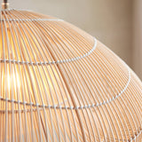 Close-up of the Endon Carlmere natural rattan pendant shade, showing the hand-woven cloud-shaped weave illuminated by a warm bulb.
