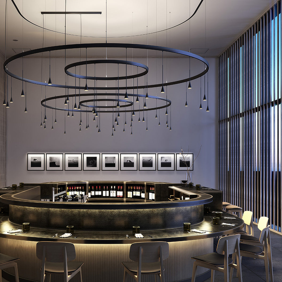 Skybell Circle Iron Ring LED Pendant Light in Ebony Black, tiered circular rings with multiple cone-shaped heads on slim stems, shown above a curved bar in a restaurant setting.