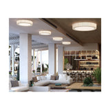 Urban PF/90 Ribbon LED ceiling lights with white pleated drum shades installed in a row along a hotel lounge ceiling above seating and a bar area.
