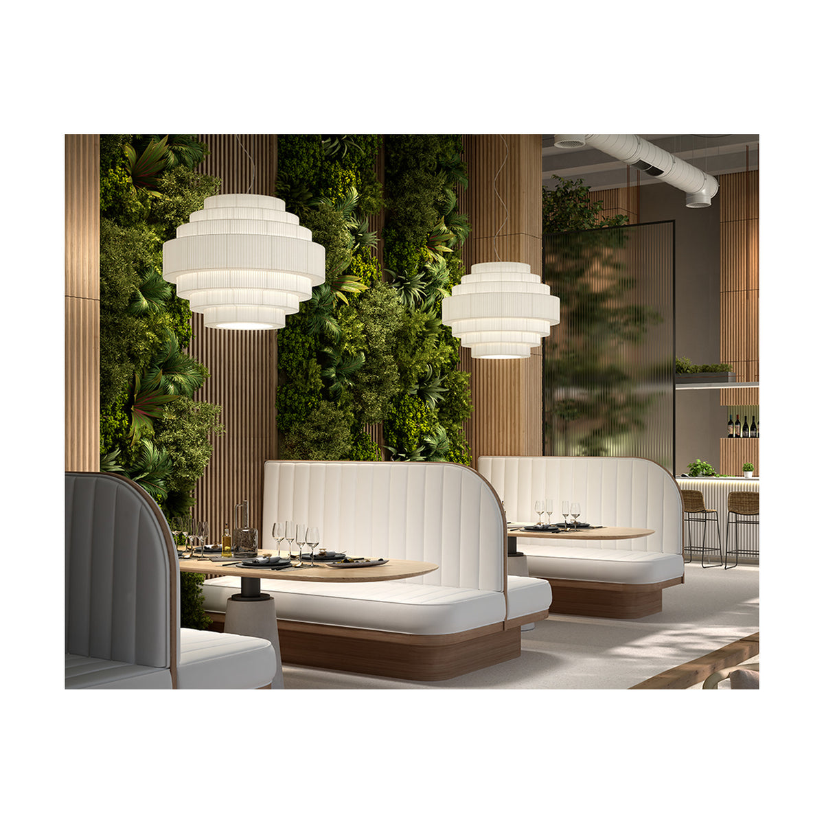 Mos 02 Ribbon Tiered Pendant Light in white translucent pleated fabric with iron frame, shown in pairs above booth seating in a restaurant dining area with greenery backdrop.