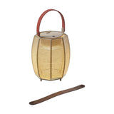 Tanit M/29/R rechargeable table lamp with faceted beige woven cotton shade, red carry handle, and matching brown leather strap on a white background.
