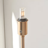 Close-up of the Endon Ashstead LED rechargeable floor lamp's aged brass holder, showing the integrated LED bulb and touch dimmer button.