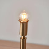 Danebourne LED Table Lamp in brushed aged brass, showing stepped metal base with glowing globe bulb against a plain light background.