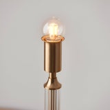 Close-up of the Endon Carlwood LED table lamp's brushed aged brass head with a lit clear globe bulb, shown against a plain light background.