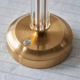 Close-up of the Endon Carlwood LED table lamp base in brushed aged brass with clear acrylic column detail and a touch dimmer button.
