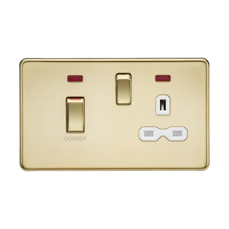 The polished brass double switch panel, identified as the 45A DP Switch & 13A Socket Neons, features two rocker switches outlined in black. The left switch is a 45A cooker control unit labeled COOKER and is positioned above two white electrical outlets on the right side.