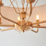 Close-up of the Endon Brenley 8 Light Pendant in vintage brass, showing the central hub, radiating arms, and two lit E14 candle lamps.