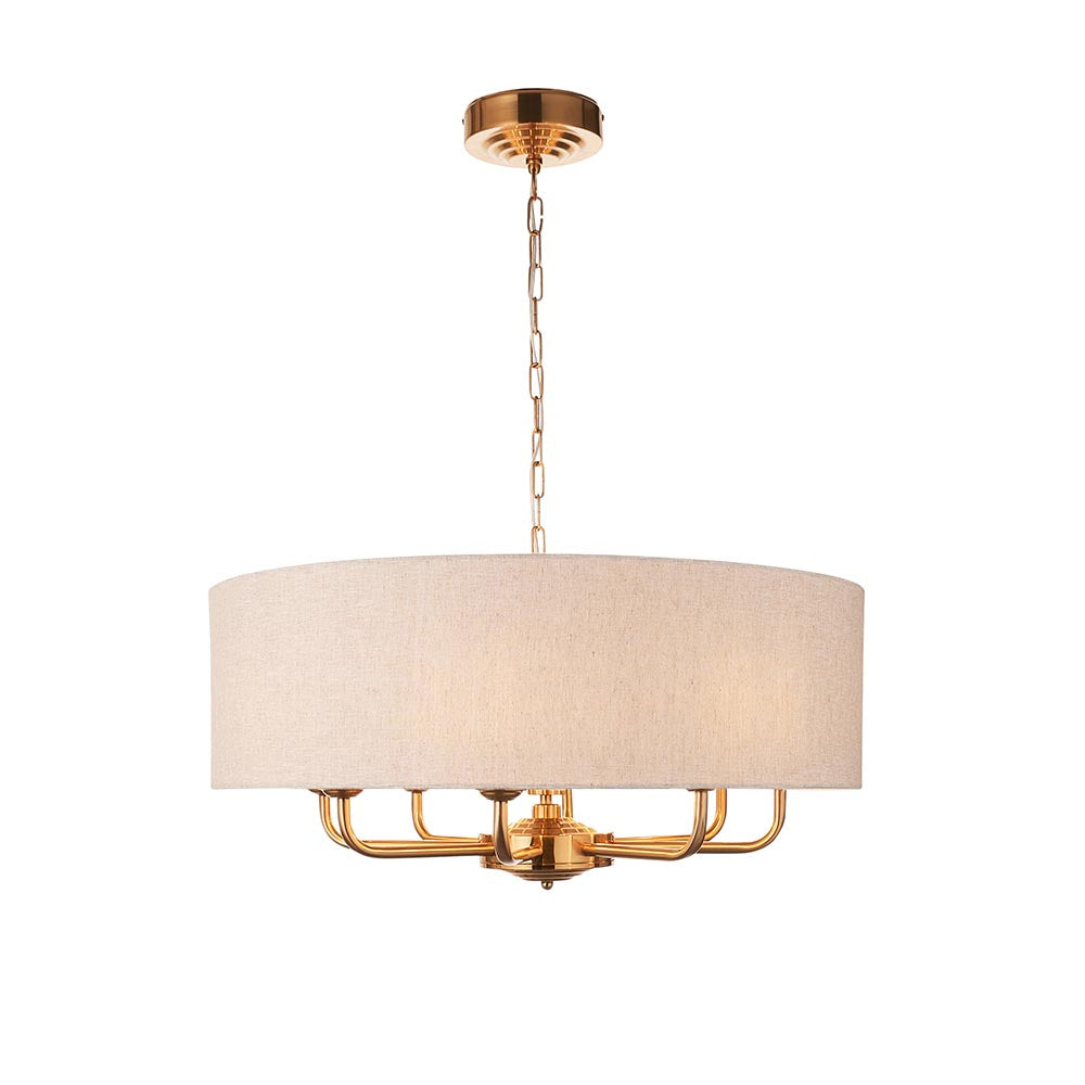 Endon Brenley pendant light with a wide natural linen drum shade and vintage brass frame holding six visible E14 arms, on a white background.