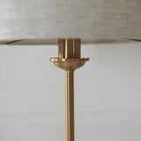 Close-up of the Endon Brenley table lamp's brass stem, fluted column and cup detail beneath the fabric shade.