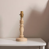 Endon Aldworth turned wood spindle table lamp in natural ash with brass B22 switched lampholder, shown shadeless on a white side table.