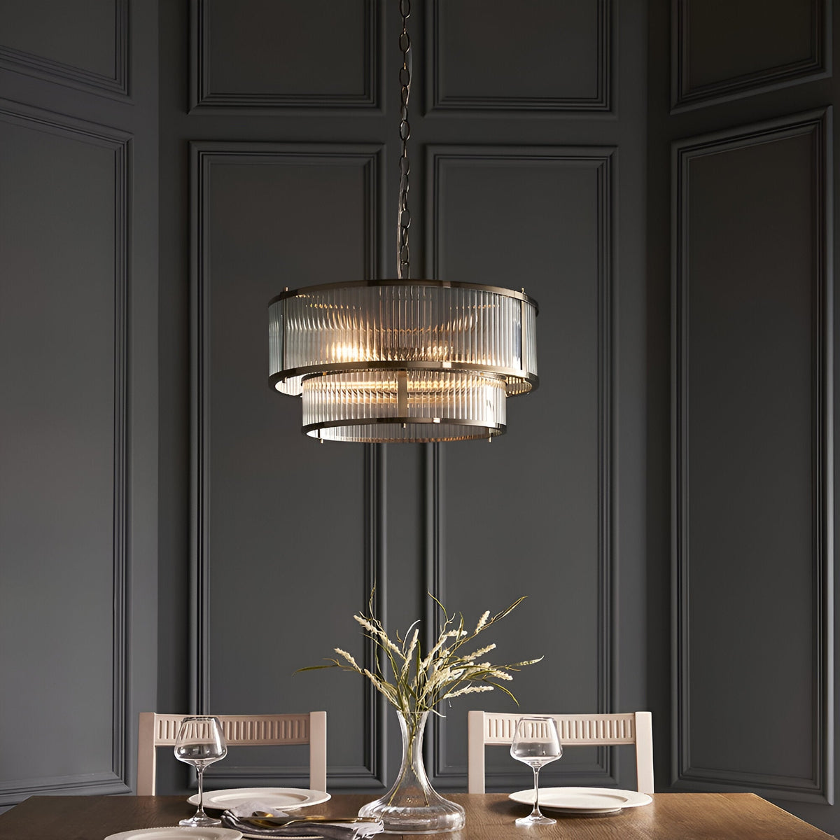 Endon Rothbury 5 light pendant in antique brass with two tiers of clear ribbed glass panel shades, suspended by chain in a panelled dining room.