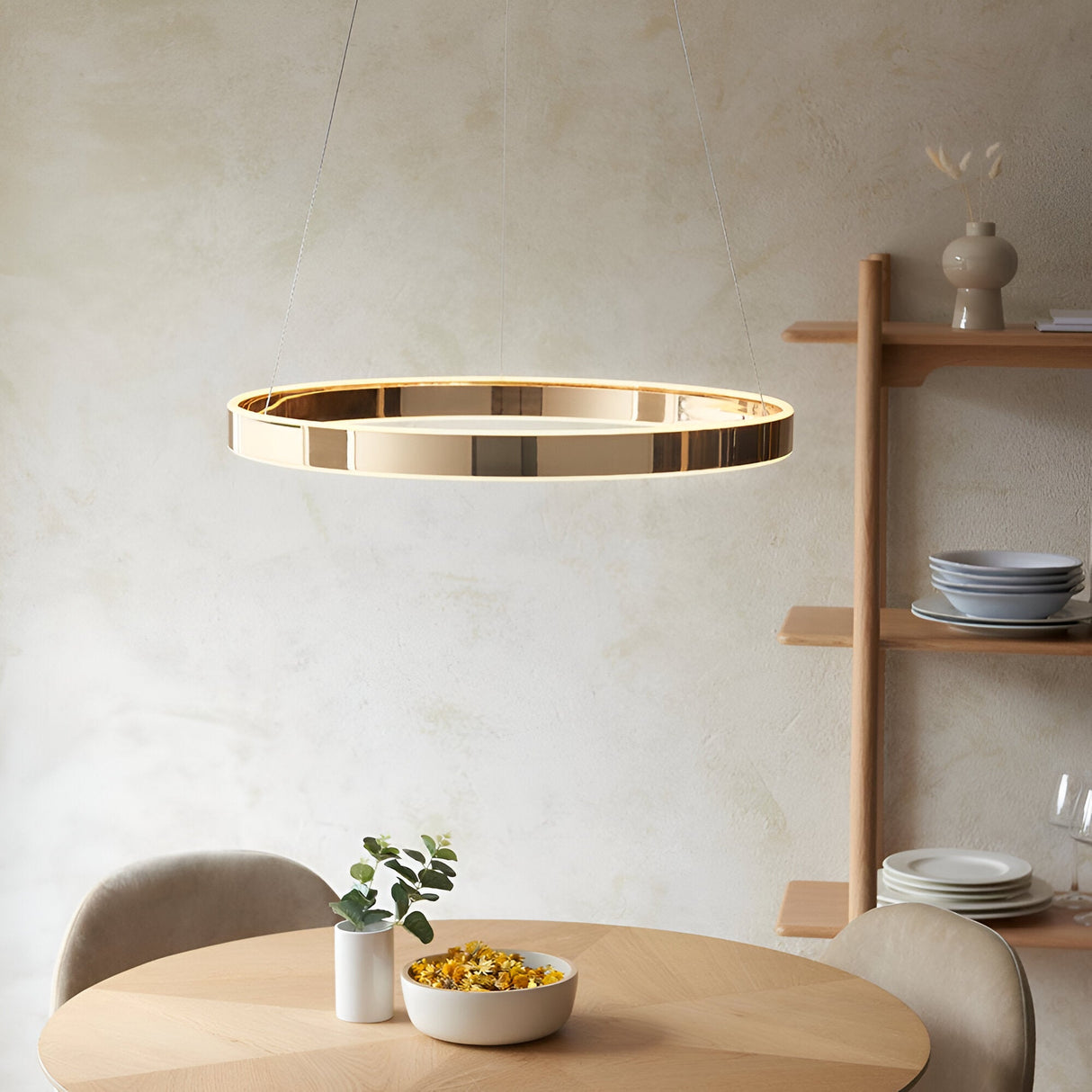 Endon Bramford gold ring LED pendant with frosted diffuser suspended on wire cables above a wooden dining table in a neutral modern room.