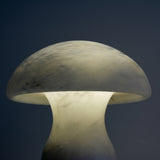 Morfia Extra Large Mushroom Alabaster Table Lamp in natural brass, close-up of the domed cap and rounded stem glowing softly against a dark background.
