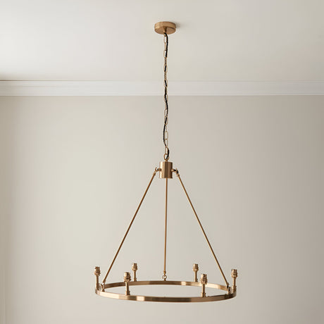 Endon Bevford 6 light hoop pendant in aged brass with six B22 lamp holders, suspended from a chain with black fabric flex against a pale wall.