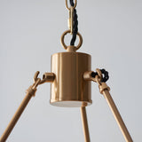 Close-up of the Endon Bevford 6 Light Pendant showing the aged brass cylindrical hub, hanging ring, black twisted fabric flex, and radiating arms.